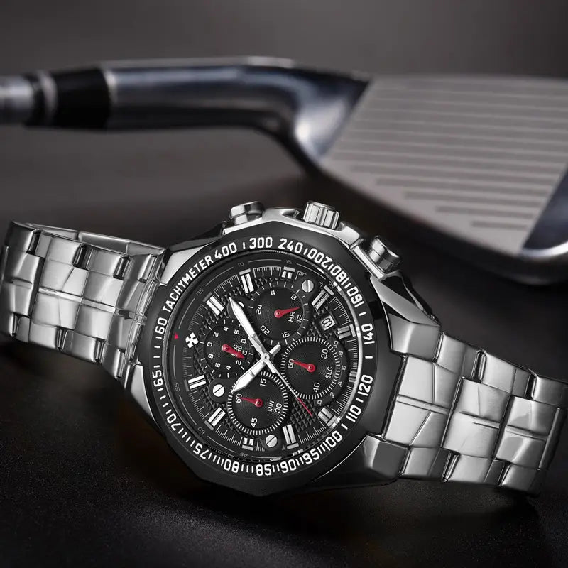 Gold chronograph watch for men featuring a silver-toned stainless steel case, black dial with red accents on the hands and subdials, and a tachymeter scale around the bezel.