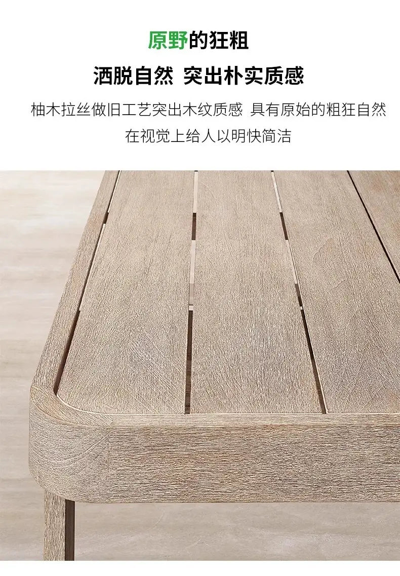 Table à lattes en bois gris brun, au relief rustique et aux motifs de veines visibles, provenant d’un ensemble de salon d’extérieur en teck avec section modulaire et brasero.