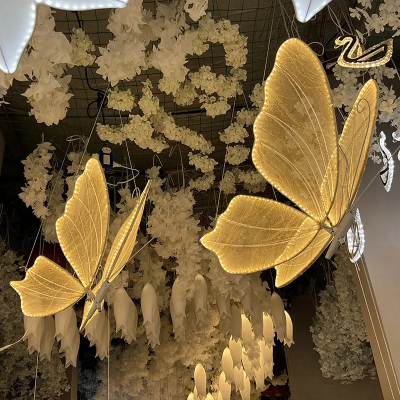 Leuchtende Schmetterlingsflügel, hängende Hochzeitstennenlichtanlage, mit goldenen, beleuchteten Schmetterlingsförmigen Deckenleuchten mit detailreicher Aderstruktur und einem eleganten Metallrahmen