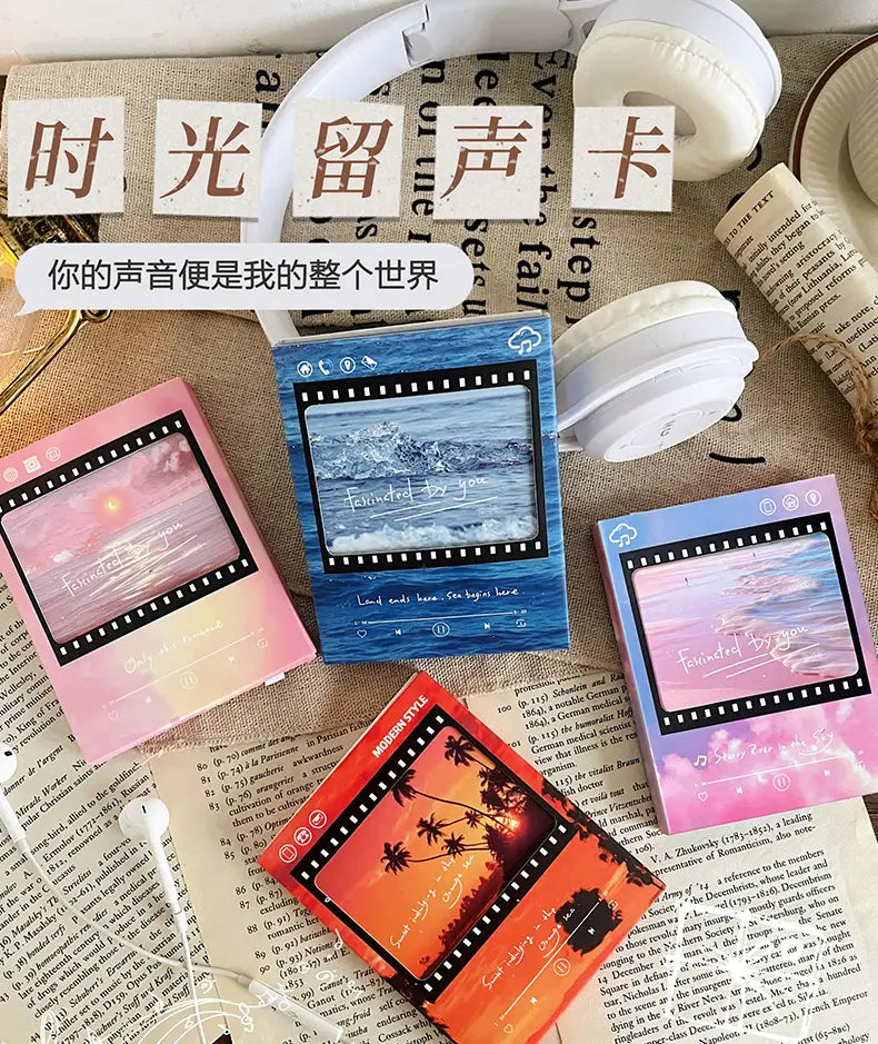 Carte de vœux musicale au style ruban de film vintage avec cassette, couleurs pastel, mettant en scène des cartes mémoire comportant des scènes imprimées d’océan et de coucher de soleil, dans un style de filmstrip.