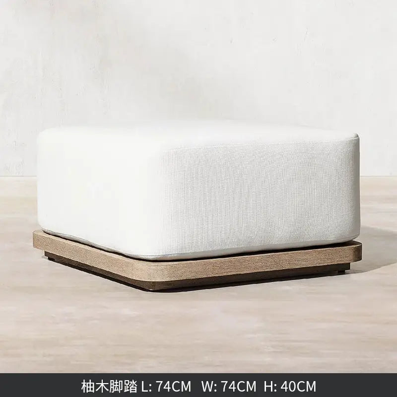 Un pouf moderne à la forme carrée, avec un dessus rembourré en lin blanc et une base robuste en teck, provenant d’un ensemble de salon d’extérieur en teck avec section modulaire et brasero.