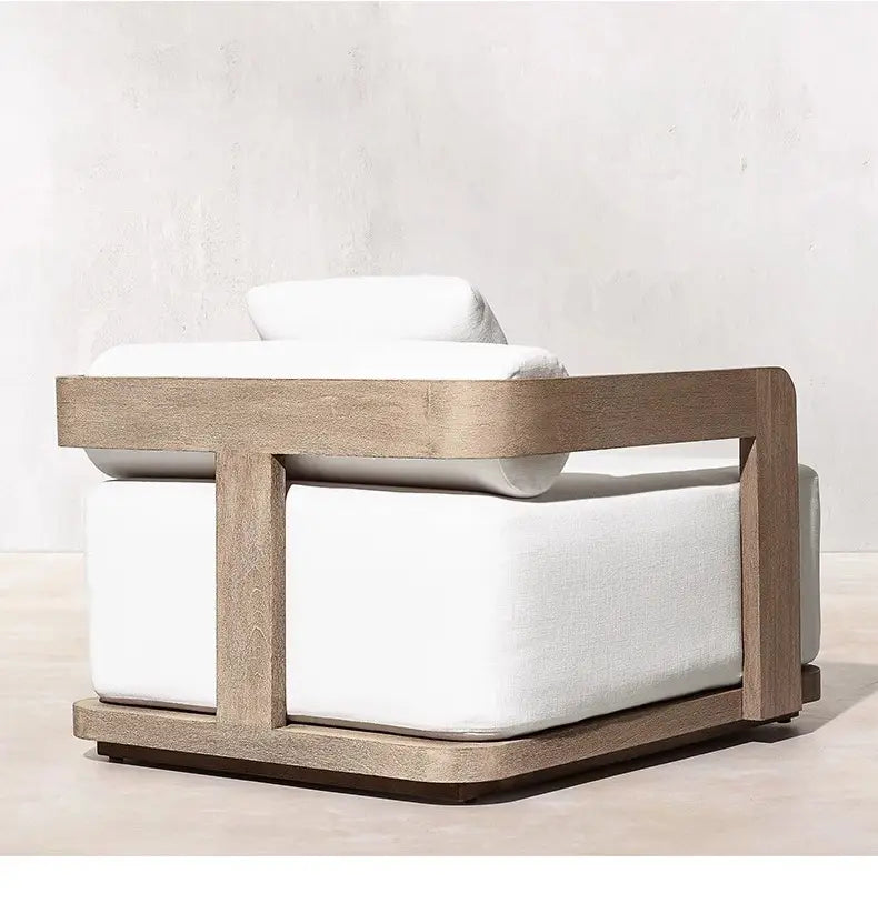 Fauteuil d’extérieur moderne, avec un cadre en bois vieilli et des coussins en tissu blanc net, provenant d’un ensemble de salon d’extérieur en teck avec section modulaire et brasero.