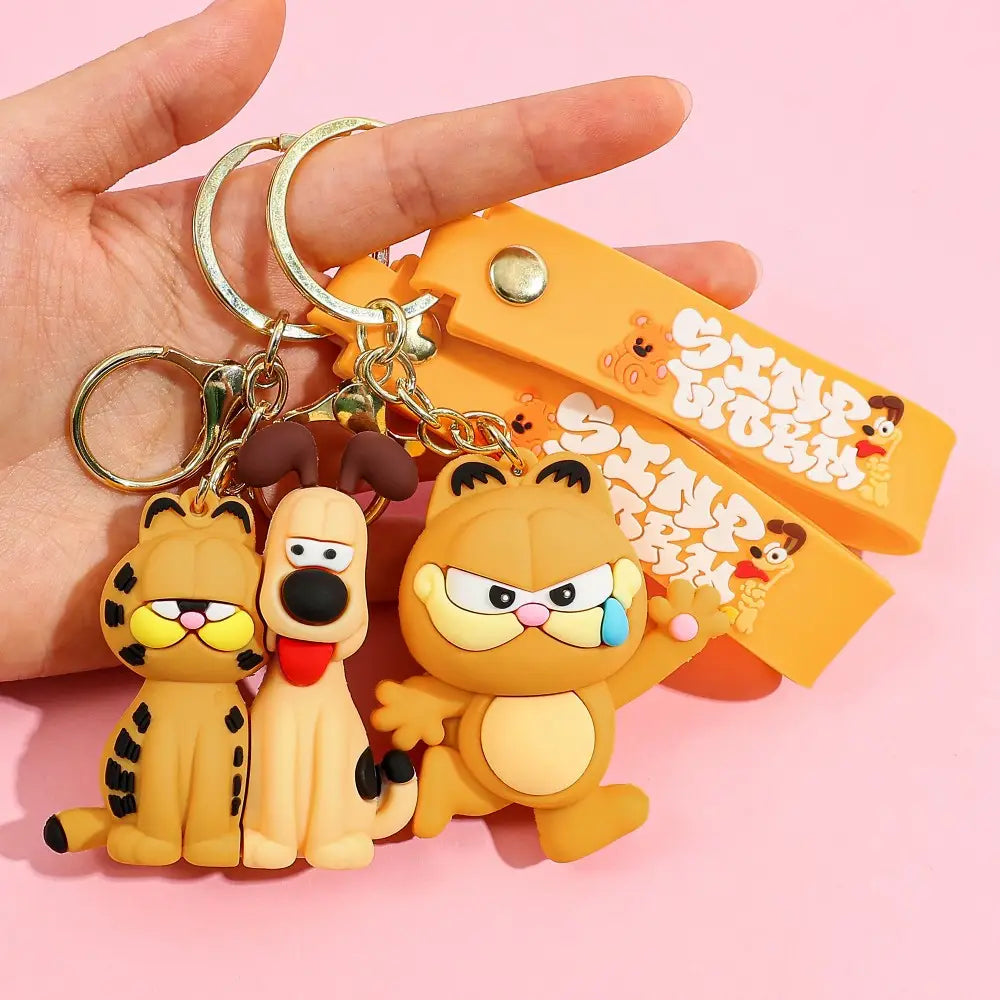 Orange rubber Garfield keychain featuring Garfield Odie and a third cat character with sinp worm printed strap designed as an anime cat key pendant.