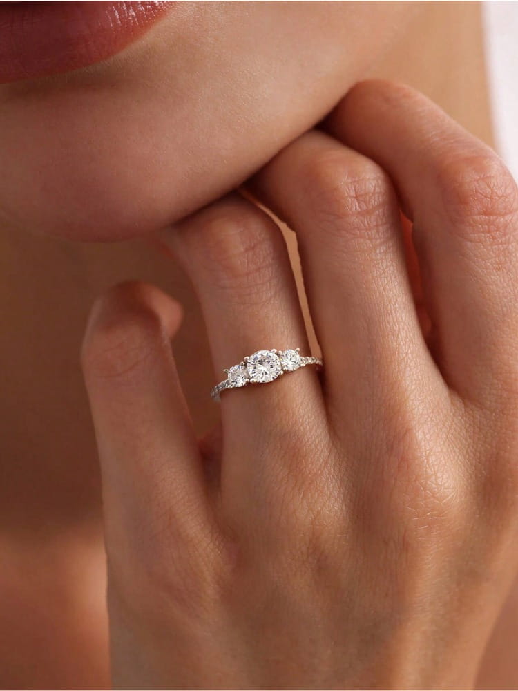Sterling silver zircon ring for women featuring a delicate three-stone design with a central round diamond flanked by two smaller diamonds on an elegant band with subtle detailing.