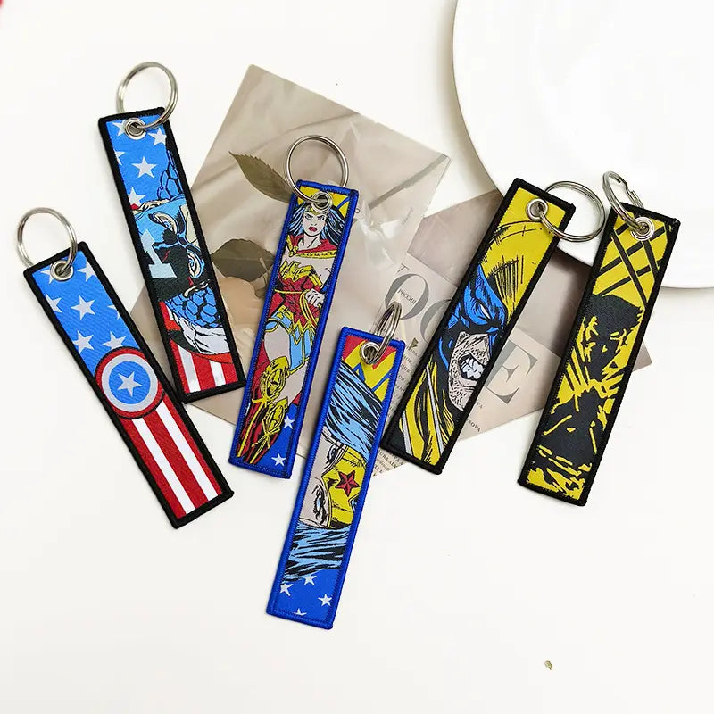 A collection of colorful rectangular embroidered keychains featuring iconic superhero designs included in the superhero embroidered keychain set anime key lanyard.