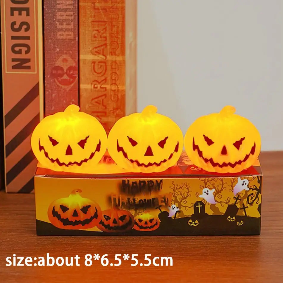 three glowing orange led halloween pumpkin lights with carved faces sit atop a decorative box in a six-pack set designed for festive indoor use