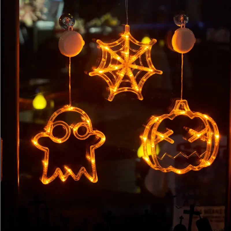 Halloween window light battery operated pumpkin ghost decor featuring glowing spiderweb ghost and pumpkin designs with warm orange LED lights for festive indoor decoration.