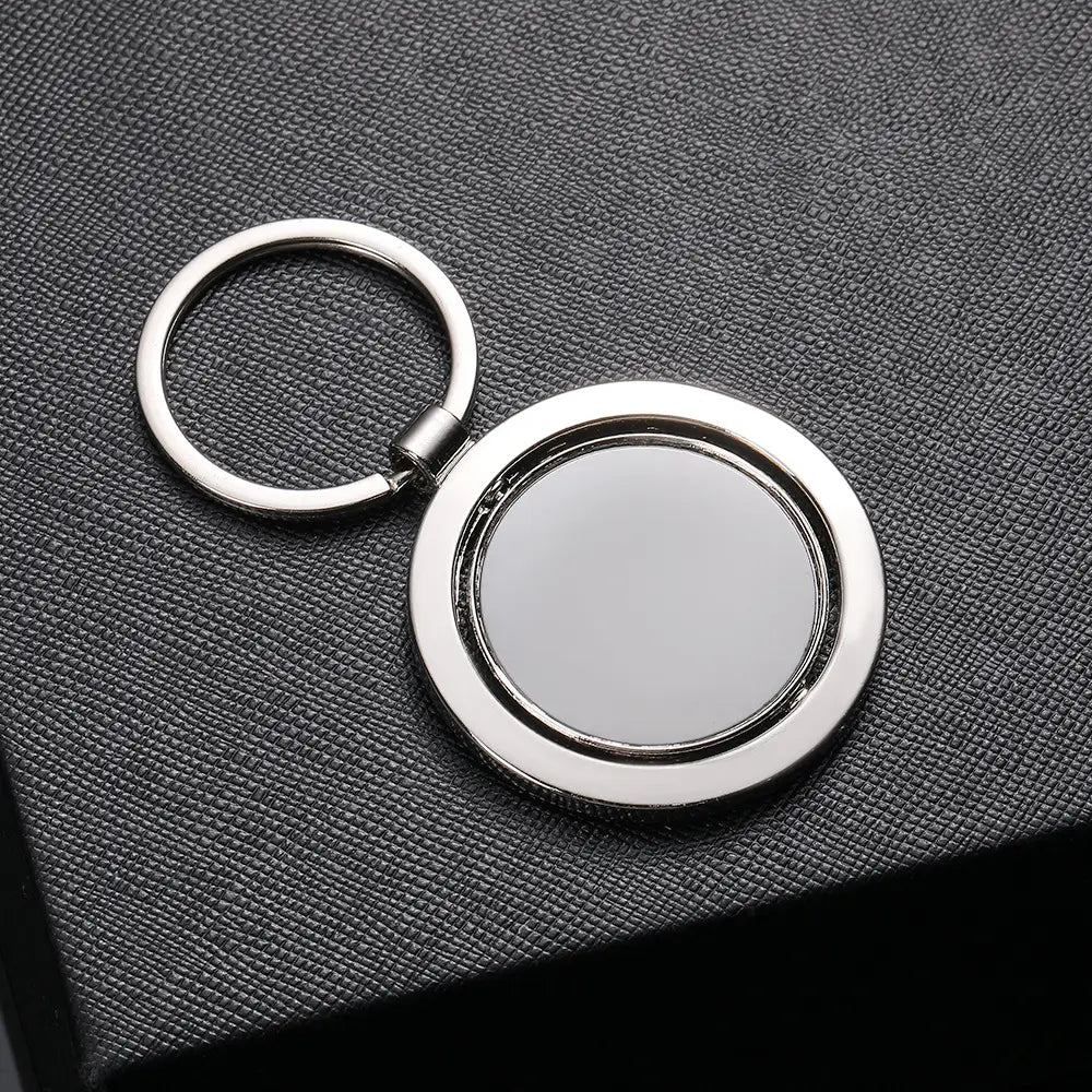 Rotating silver circle keychain with a smooth reflective surface and polished metallic finish.