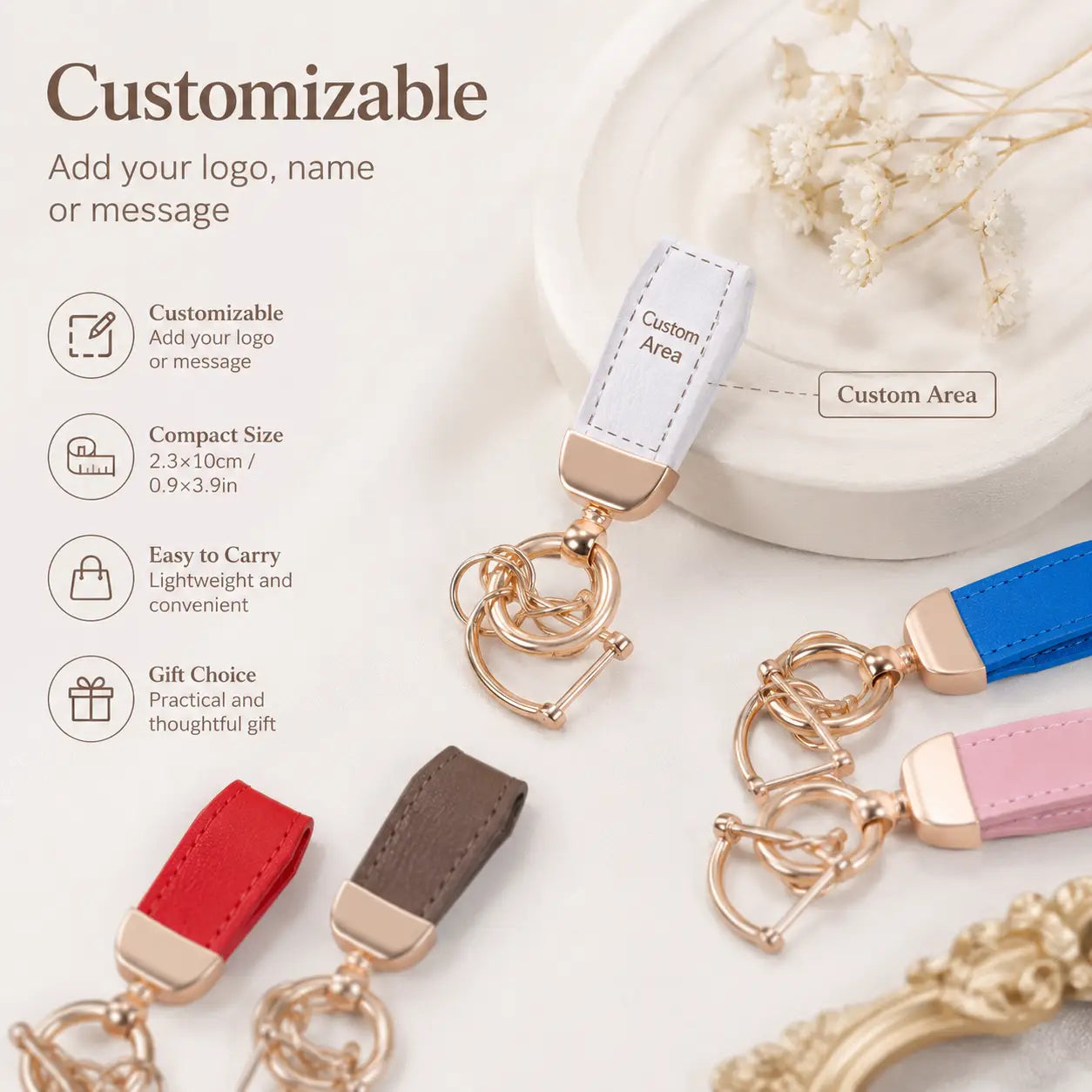 A customizable personalized leather keychain with a leather strap in red brown blue and pink featuring gold toned metal hardware for use as a custom engraved key holder.