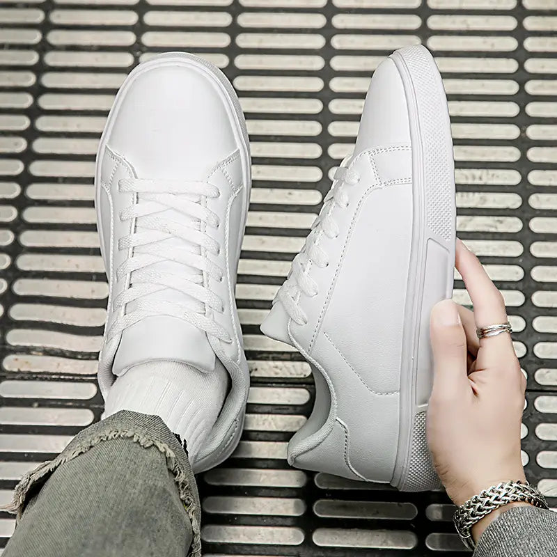 Weiße Ledersneaker im Freizeitstil zeichnen sich durch ein minimalistisches Design mit klaren Ziernähten und einen leichten Aufbau aus, ideal für Sport und den täglichen Gebrauch.