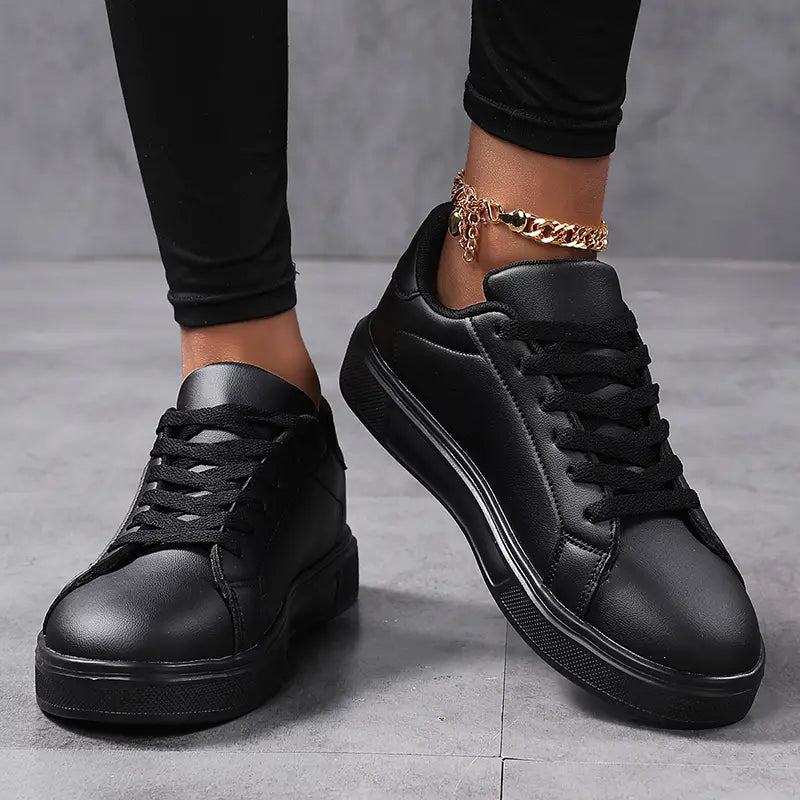 Schwarze Ledersneaker im Low-Top-Format mit dicken Sohlen und schwarzen Schnürsenkeln, als leichte Sportschuhe für die Freizeit konzipiert