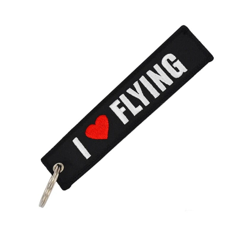 フライト前に取り外してください。白い「i heart flying」表記が入った赤いハートと銀色の金属リングを備えた刺繍キーチェーン。