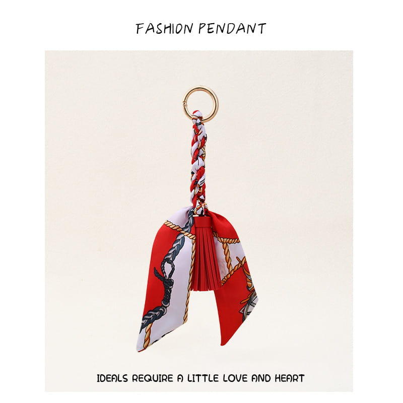 Porte-clés à gland de foulard en soie pour sacs, avec un foulard en soie rouge et blanc à motif, et une bague en métal à finition dorée.