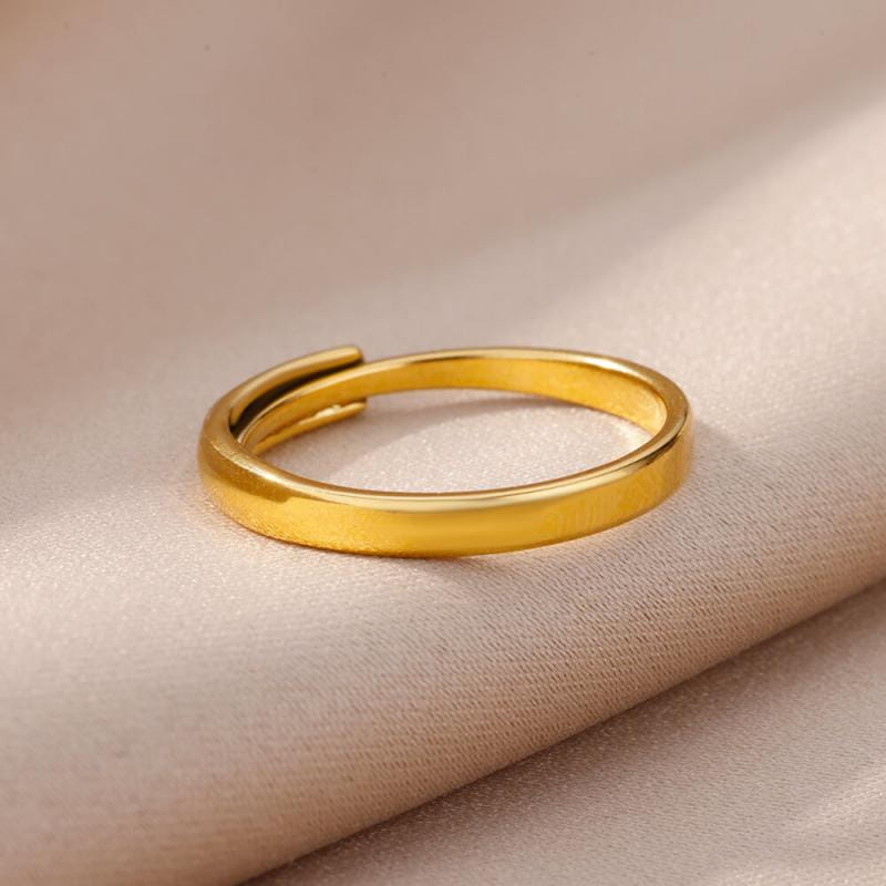 A sleek gold color stainless steel adjustable ring for women with a smooth polished finish and minimalist vintage wedding jewelry design.