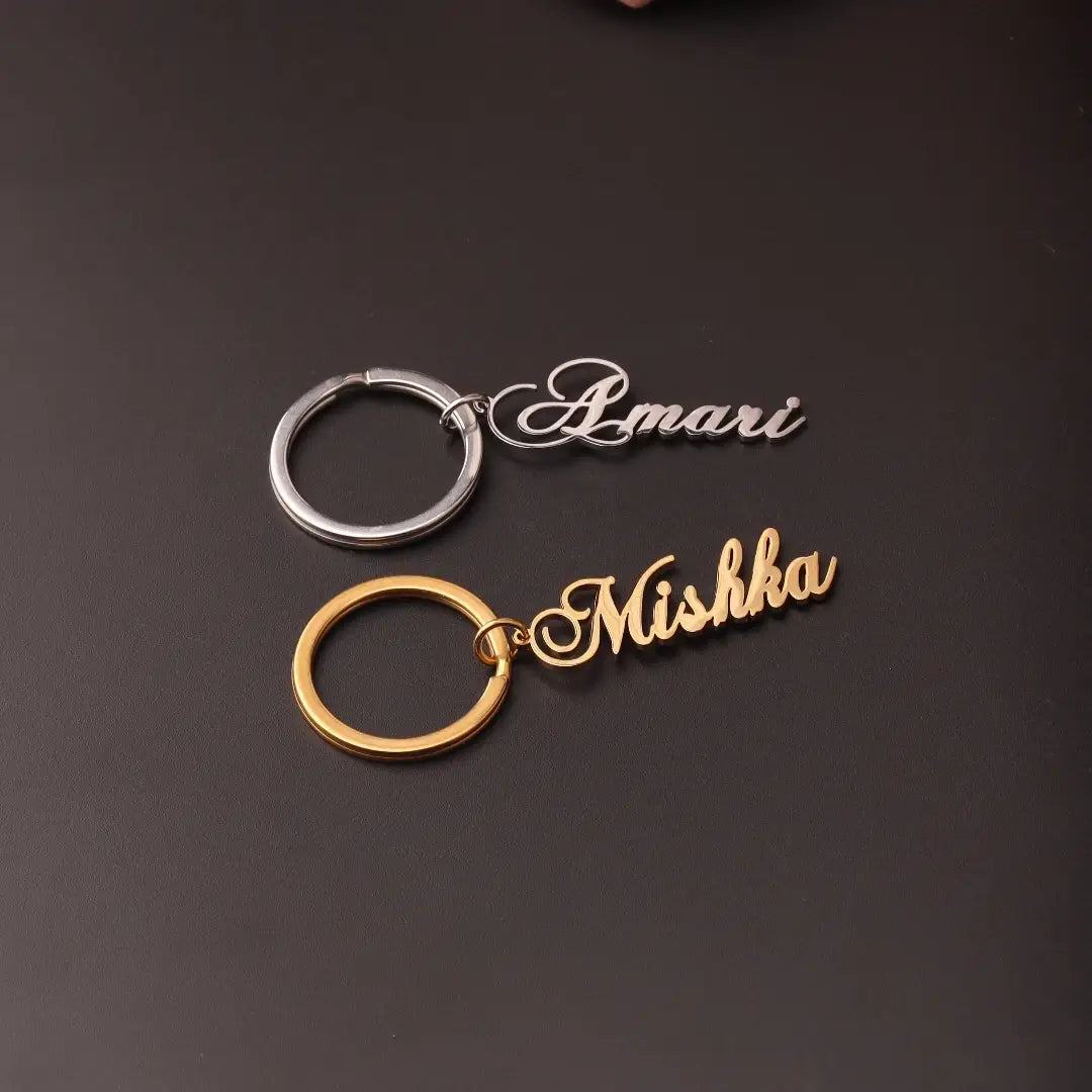 two personalized custom name keychains in stainless steel with a silver finish engraved with amari and a gold finish engraved with mishka each featuring sleek metallic rings designed as a gift