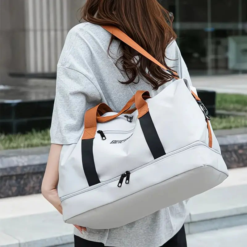 Sac de sport duffel blanc et camel avec accents de fermeture éclair noirs, fabriqué en tissu Oxford, conçu comme un sac de sport de voyage Oxford weekender duffle de fitness.