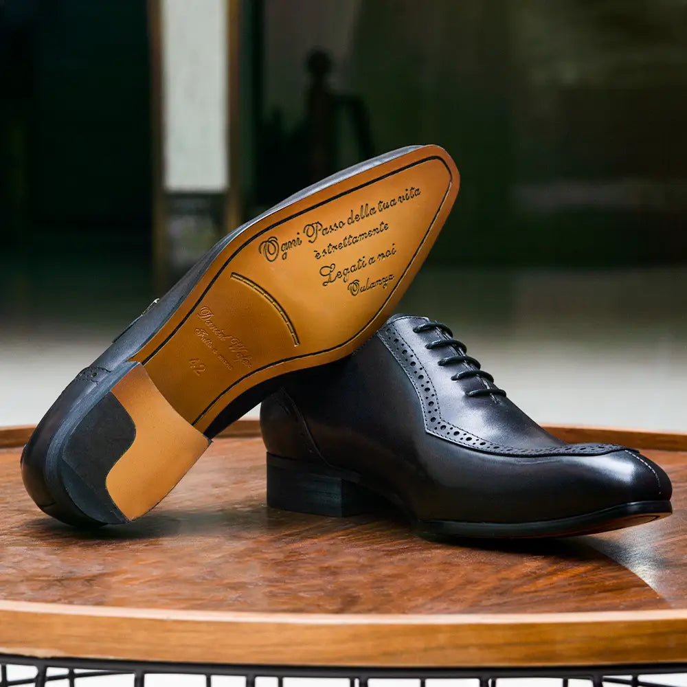Chaussures de ville à bout brogue type derby Oxford pour homme en cuir véritable noir, finition polie et semelle intérieure beige, avec texte italien en relief.