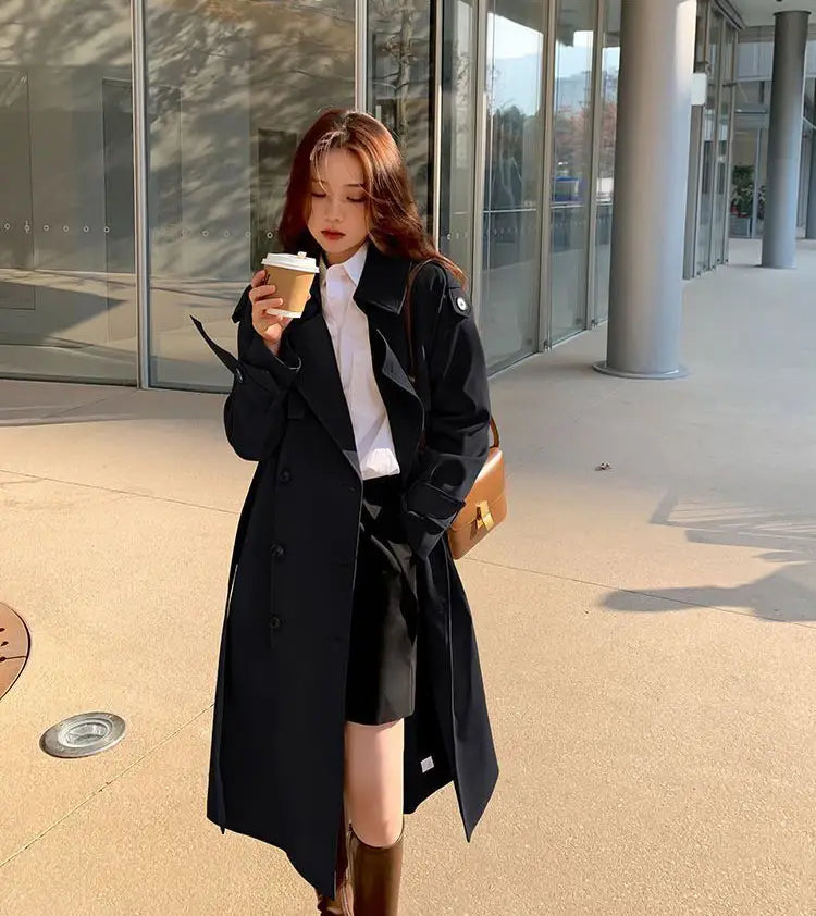 Black trench coat for women with a classic double-breasted design and subtle button detailing.