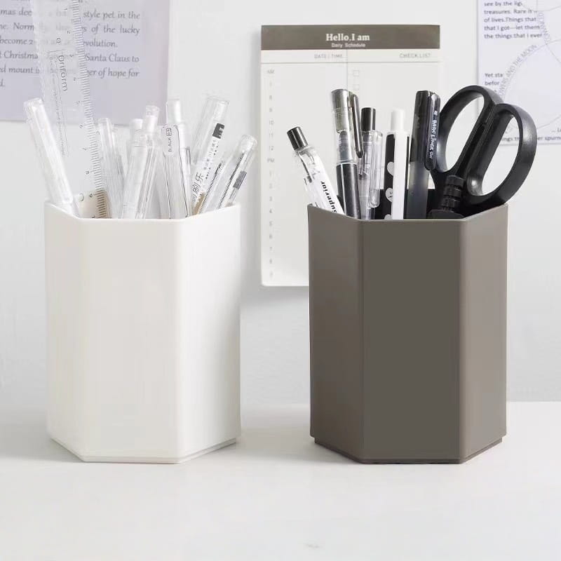 Deux porte-stylos en plastique hexagonaux pour bureau, de couleur blanche et grise, remplis de stylos, de crayons et de ciseaux.