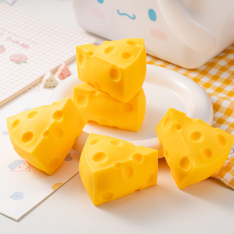 Balles antistress en silicone jaune vif, qui s’écrasent et montent lentement, en forme de fromage, avec des trous caractéristiques, idéales comme cadeaux pour les fêtes.