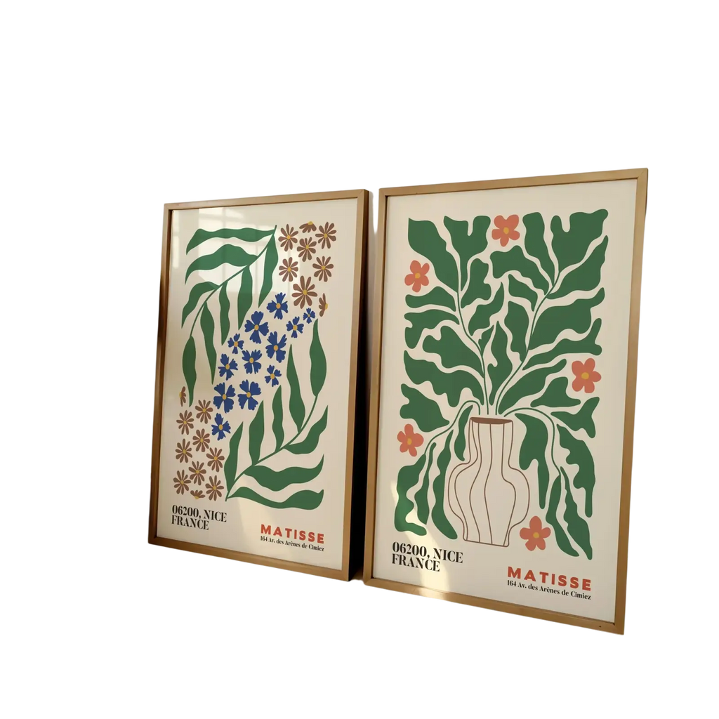Two framed Matisse flower prints with stylized green blue and orange botanical illustrations on cream backgrounds
