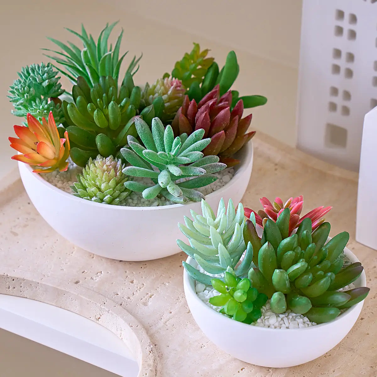 white ceramic bowl made using a round silicone mold for concrete filled with artificial succulents in various shades of green red and orange for storage and decorative purposes