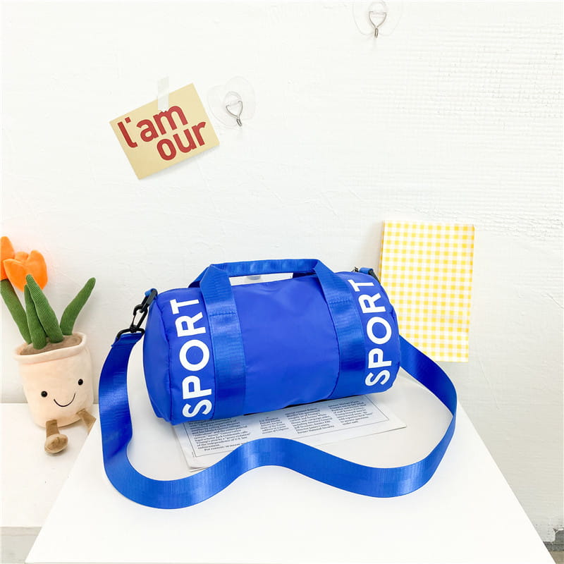 Leuchtend blaue zylindrische Kinder-Sport-Reise-Sporttasche mit weißer Sportbeschriftung und verstellbarem Crossbody-Riemen für die Nutzung als Reise- und Gym-Gepäck.