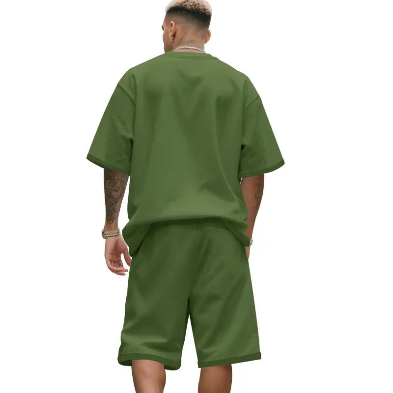 Conjunto para hombre de camiseta oversize verde oliva de manga corta a juego y pantalones cortos para el verano casual de dos piezas.