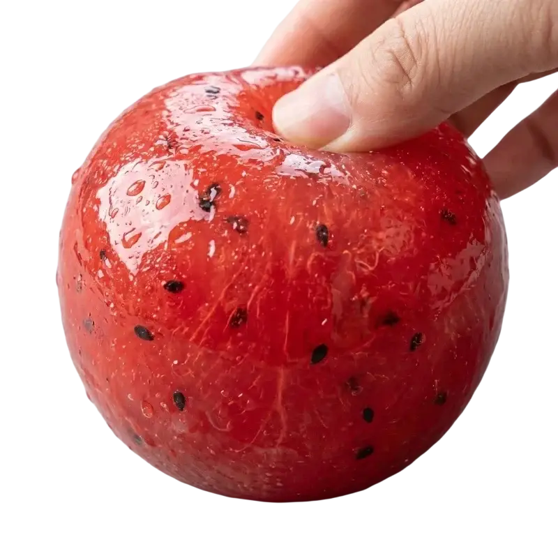 A handmade red dragon fruit watermelon slushy squishy toy with black seeds held from the top front angle