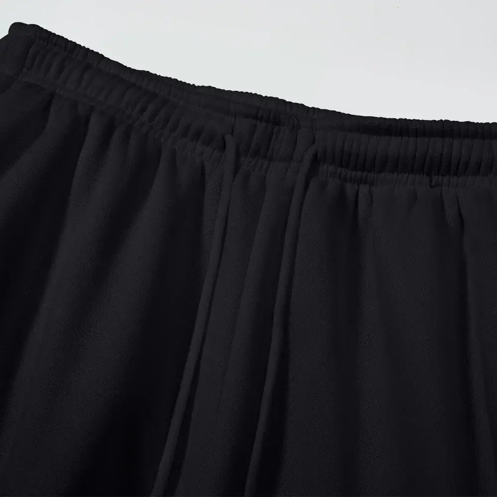Pantalons cargo plissés noirs pour homme, à taille élastique, en tissu doux, pour une coupe ample et un style jogging confortable.
