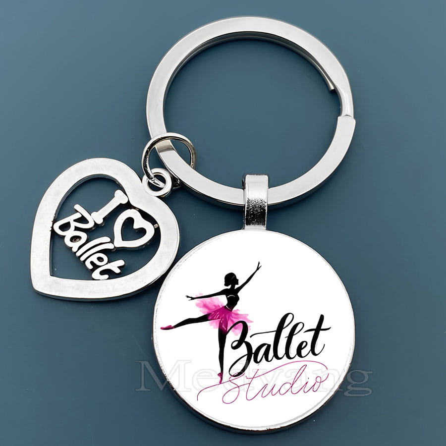 銀色のバレエキーチェーン。ハート形のチャームには「I love ballet」が施され、ガラスドームの丸いディスクにピンクのチュチュのダンサーシルエットと「ballet studio」の文字が表示されたデザイン。