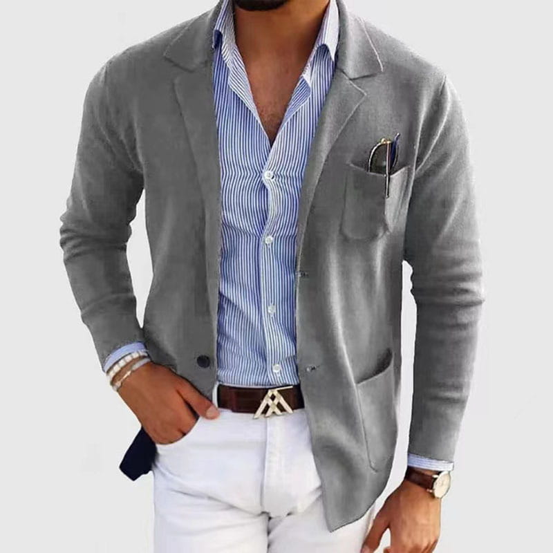 Chaqueta tipo blazer gris, de ajuste entallado, para hombre, con un brillo sutil, usada abierta sobre una camisa abotonada a rayas azul y blanca como chaqueta de traje sólida con estilo.