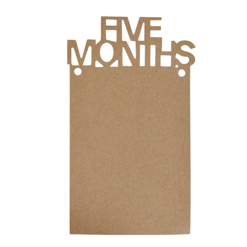Brown cardboard plaque with five months cut out in uppercase letters used as part of a 1st birthday photo banner monthly picture garland.