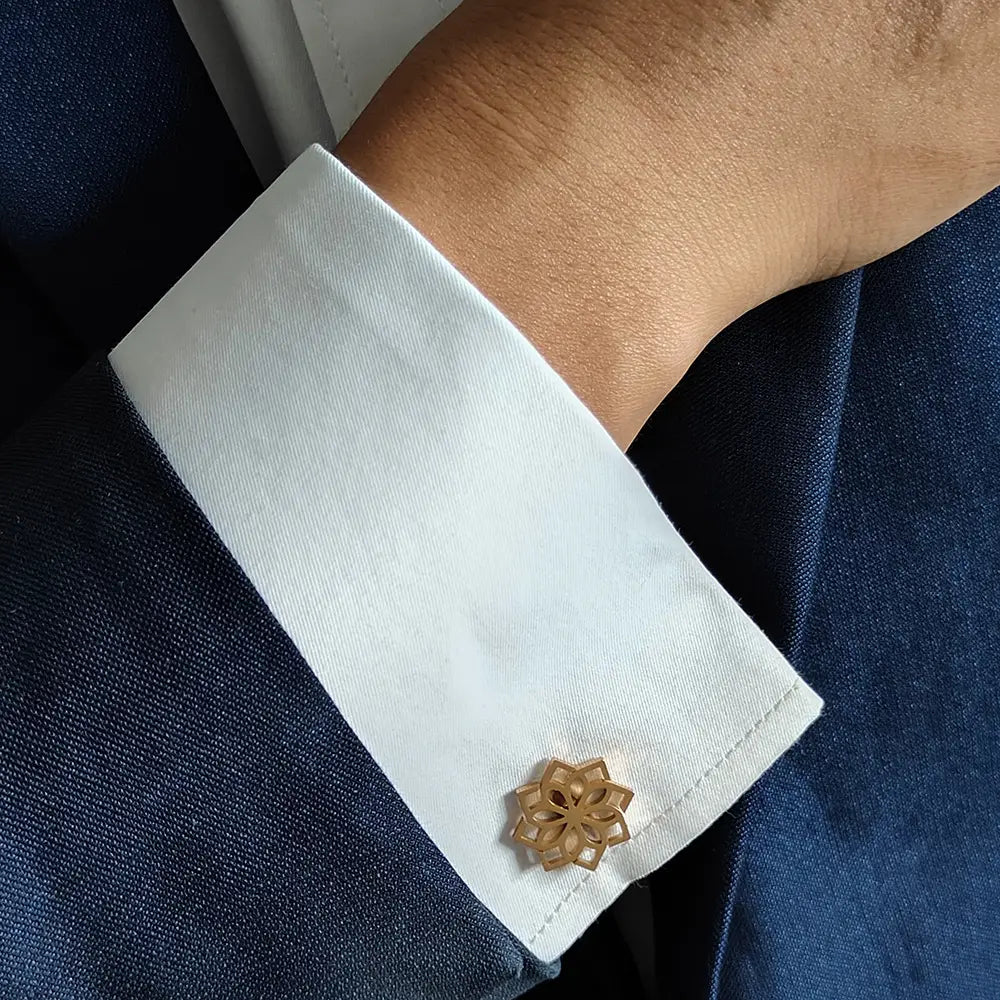 stainless steel floral cufflinks for men featuring a gold-toned intricately cut design adorning a crisp white shirt cuff