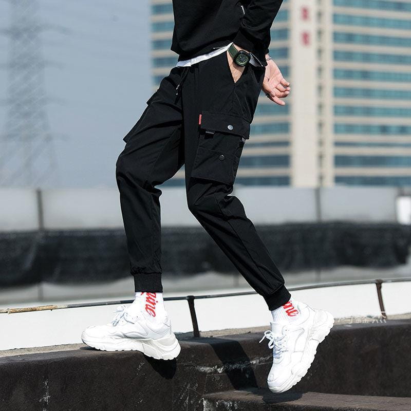 Men tactical cargo pants in black featuring multiple pockets and a drawstring waistband designed as casual joggers.