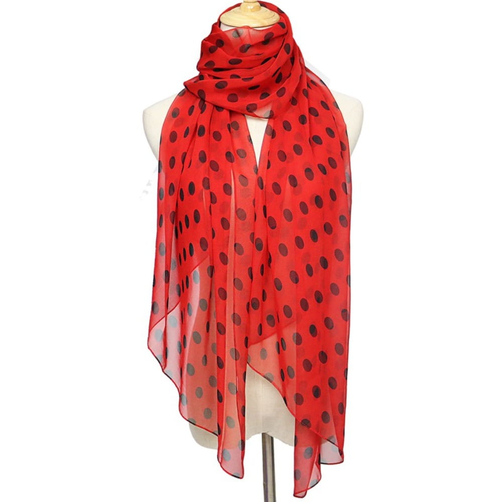 Red polka dot silk head wrap scarf with black dots made of sheer fabric.