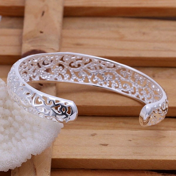 Sterling silver filigree cuff bracelet featuring an open bangle design with intricate lace-like patterns and embedded clear stones.
