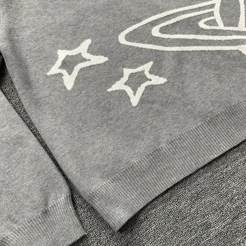 suéter de punto gris con estrellas bordadas en blanco y un diseño de anillo planetario en un estilo casual de suéter de punto con gráfico