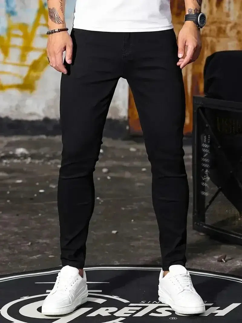 Jeans en denim bleu foncé coupe slim pour homme présentant un design moderne et élégant, ainsi que des détails de coutures subtils.