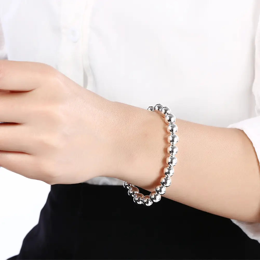 Bracelet en argent orné de perles en argent sterling, porté au poignet dans le cadre d’un ensemble de parure en argent orné de perles comprenant un collier.
