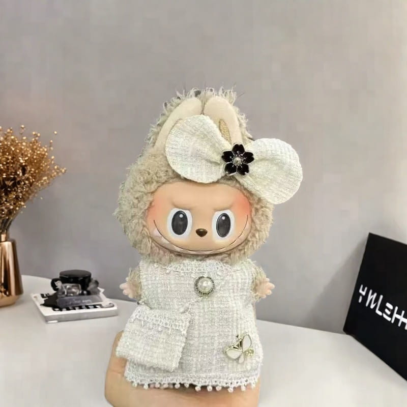 ラブブ黒と白のタータン柄ドール衣装セットを着用した、クリーム色のうさぎをテーマにしたぬいぐるみドール。レースのトリム付きの質感のあるツイードのコートと、パールの装飾が施されています。