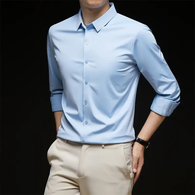 Camisa de vestir para hombre sin arrugas color azul claro, con mangas largas y puños enrollados, preparada para ocasiones formales.
