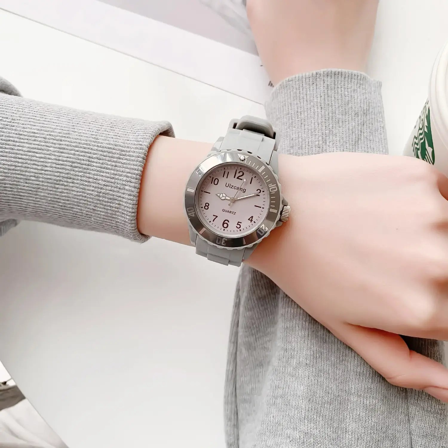 Kids silicone quartz watch with a gray silicone strap, silver-toned case, and light pink dial featuring black Arabic numerals.
