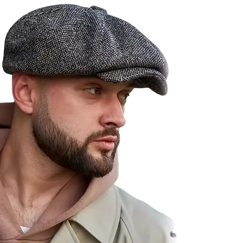 Eine strukturierte graue Schiebermütze aus Fischgrät-Tweed mit einem klassischen Acht-Panel-Design, inspiriert vom Vintage-Peaky-Blinders-Stil.