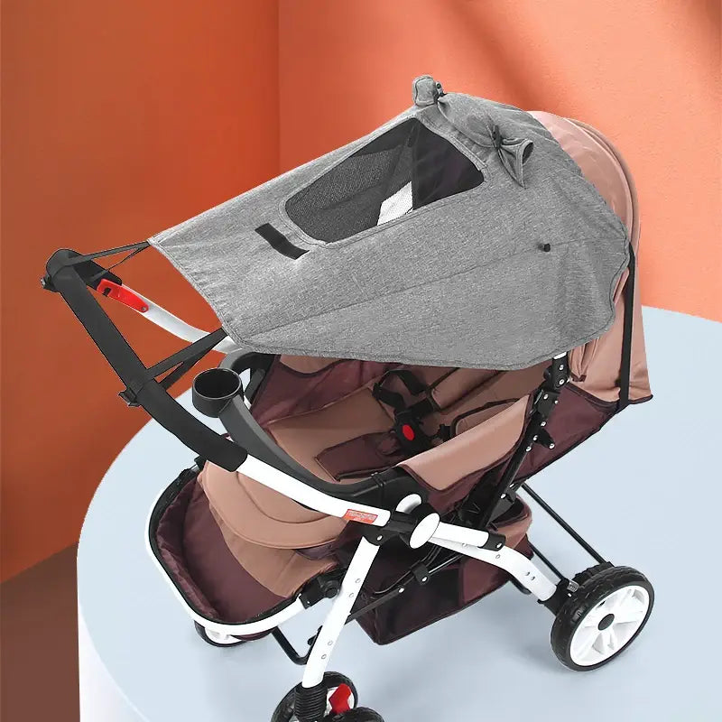 Grauer Mesh-Stoff für den universellen Kinderwagen-Sonnenschutz UPF50 mit Bogen-Detail, ausgelegt für Schatten und Belüftung über einem Kinderwagen