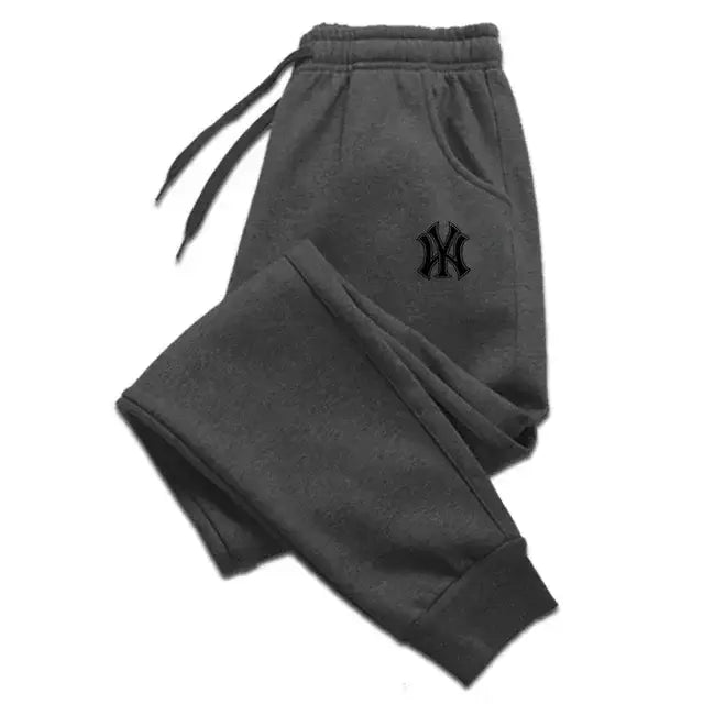 Sudaderas tipo jogger de felpa para hombre de Yankees en felpa gris oscuro con un logotipo bordado de Yankees en color negro en el muslo izquierdo.