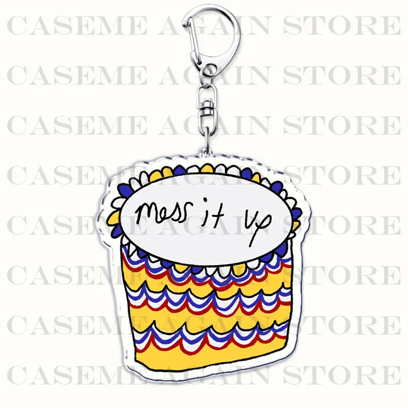 A colorful acrylic keychain shaped like a cupcake with yellow red and blue wavy stripes and the phrase mess it up on its white top designed as a Gracie Abrams anime fan gift.