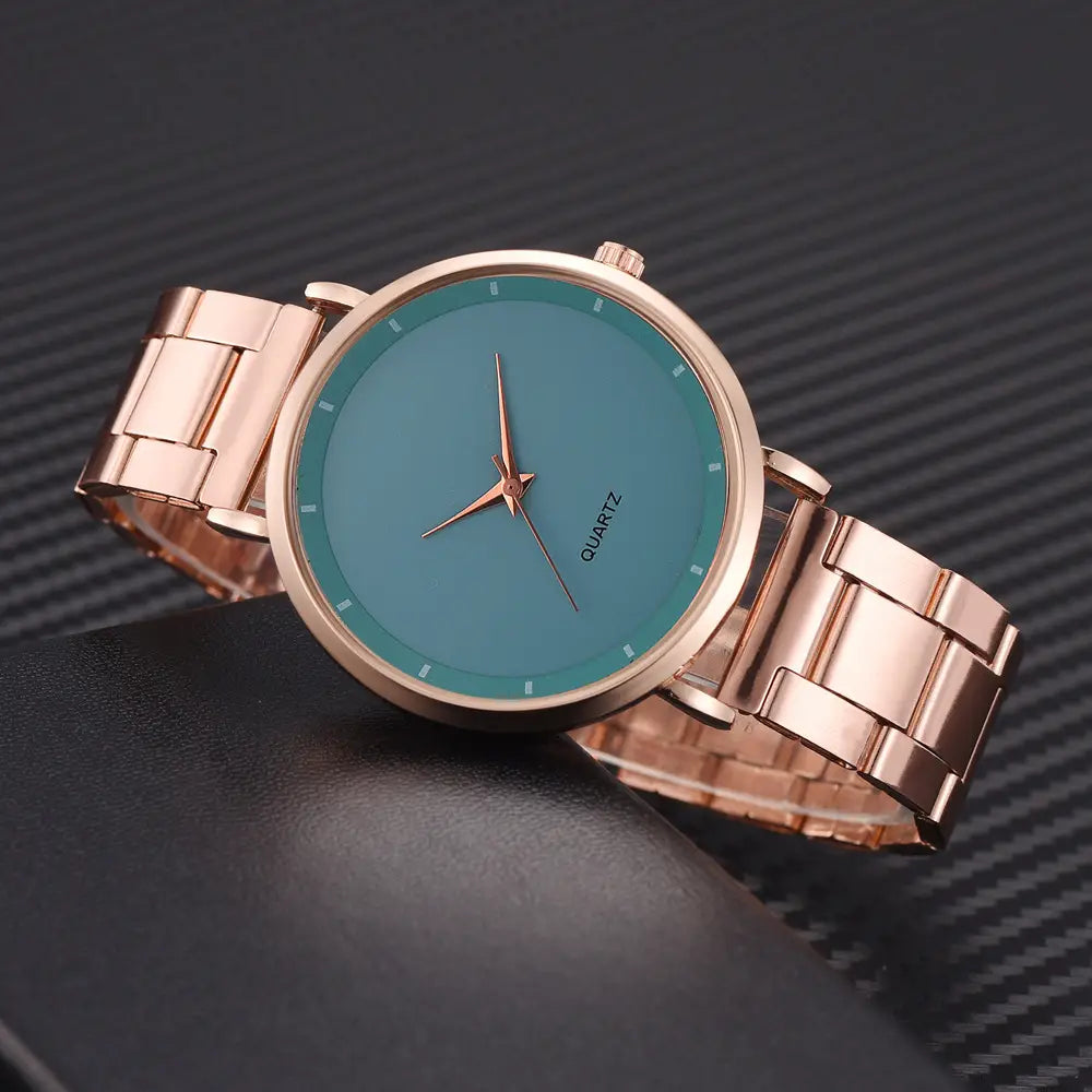 Rose gold women luxury watch quartz business wristwatch with a rose gold-tone stainless steel band, solid teal dial, and slender hands featuring a sleek minimalist design.