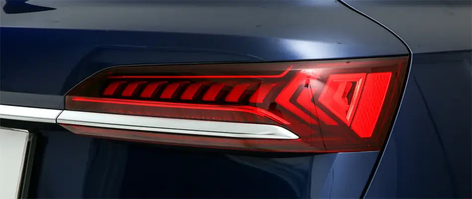 La face arrière du couvre-carter de remplacement du feu arrière Audi Q7 2020-2024 présente un design moderne et épuré, avec des motifs géométriques LED rouges éclatants intégrés à une carrosserie peinte en bleu foncé.