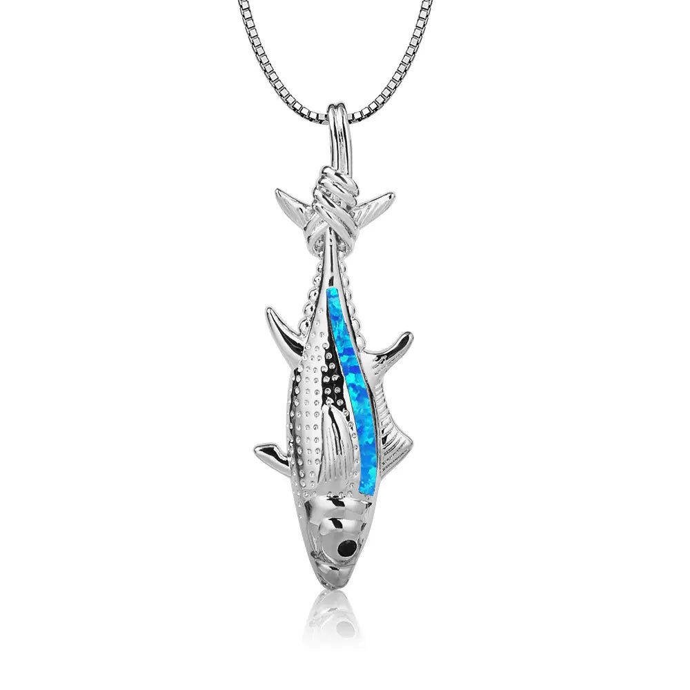 Collier pendentif en forme de poisson en argent, présentant un placage d’opale bleue éclatant le long de son côté, avec des écailles et des nageoires texturées détaillées dans un style de bijou marin.